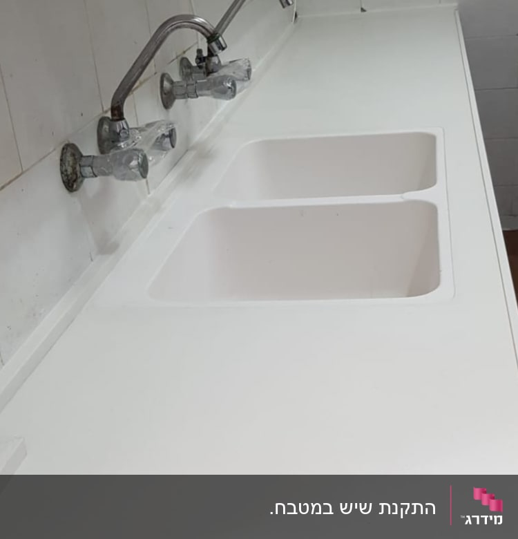 שיש לבן עם כיורים וברזים כפולים